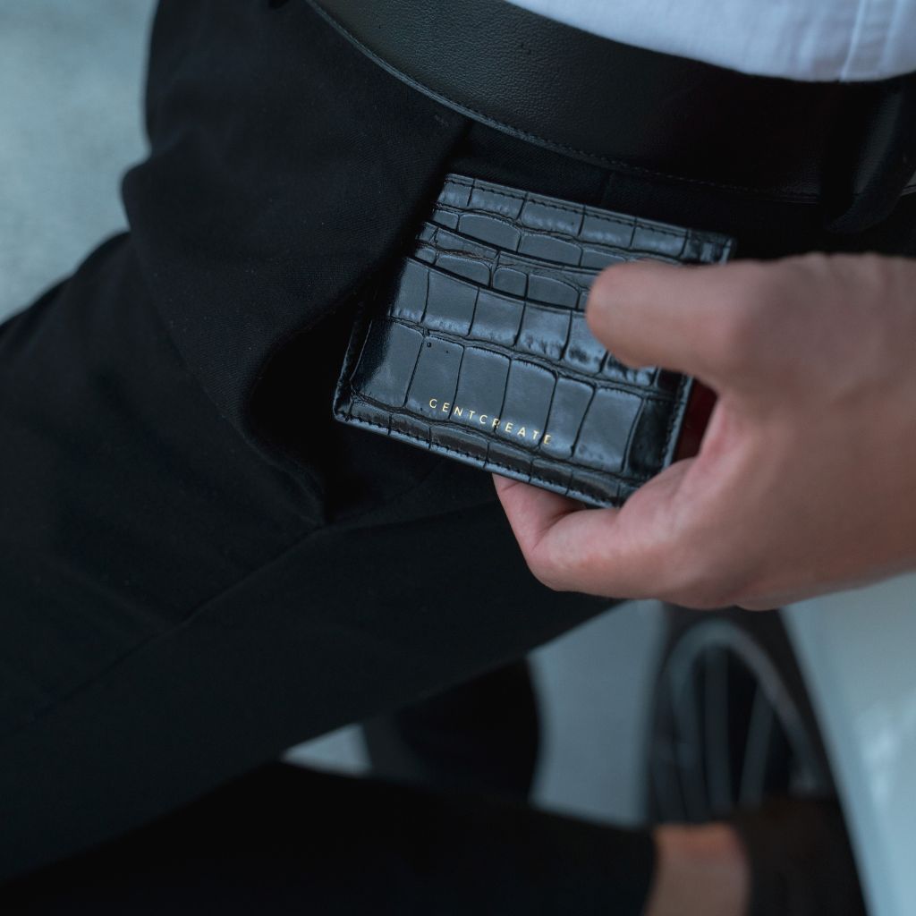 A man holds a black calfskin leather cardholder with a crocodile pattern from the Gentcreate brand.