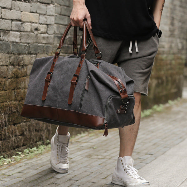 The man carries in his hand a vintage shoulder traveel bag gentcreate