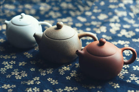 three teapots on tablecloth