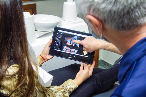 dentist showing patient x-ray of teeth