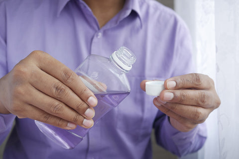 man holding bottle of mouth wash