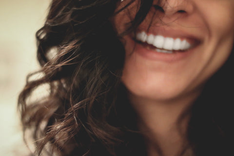 womans face smiling with shiny white teeth