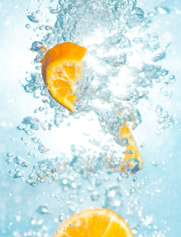 orange slices dropping into water