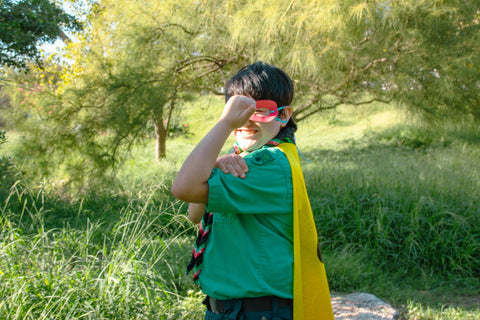 boy in green top and yellow cape dressed as superhero