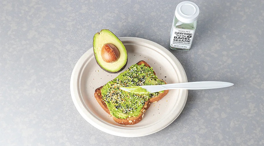 Avocado toast on bagasse plate with spoon and green food coloring bottle