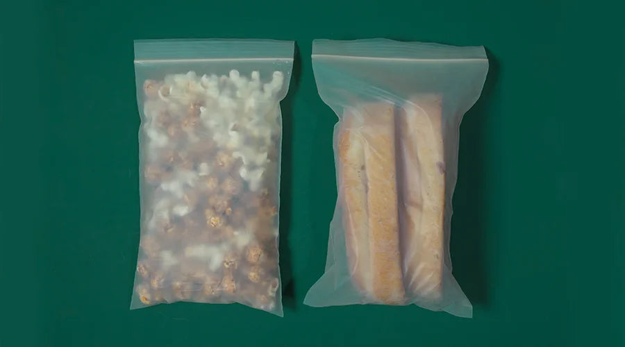 Two PLA Ziplock bags filled with food items placed on a green surface