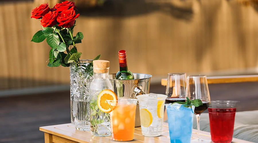 An image of a table showcasing beverages and floral arrangements, with compostable glass cups.