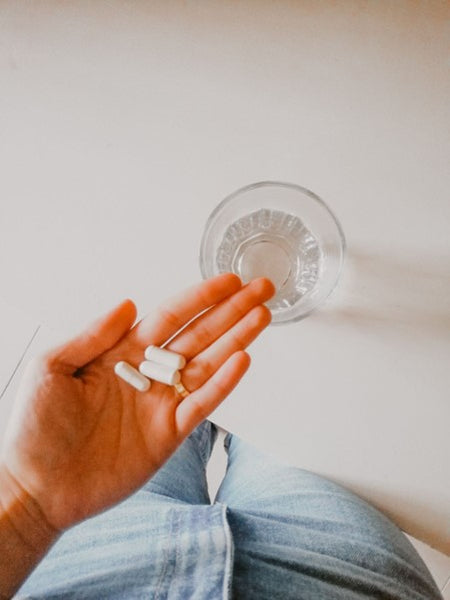 Person taking supplements with water