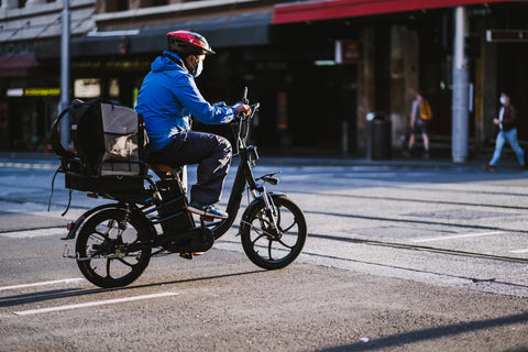 Delivery man on a motorbike wearing a fabric face mask