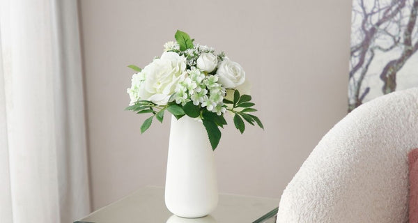 Flores artificiales blancas en jarrón.