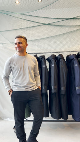 Image of the founder of bedi Studios; Inder Bedi candidly shot in front of a rack of his sustainable outerwear creations
