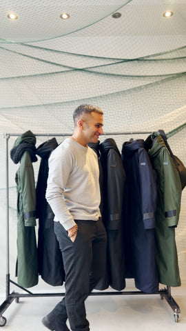 The founder of Bedi Studios; Inder Bedi candidly shot in front of a rack of his sustainable outerwear creations