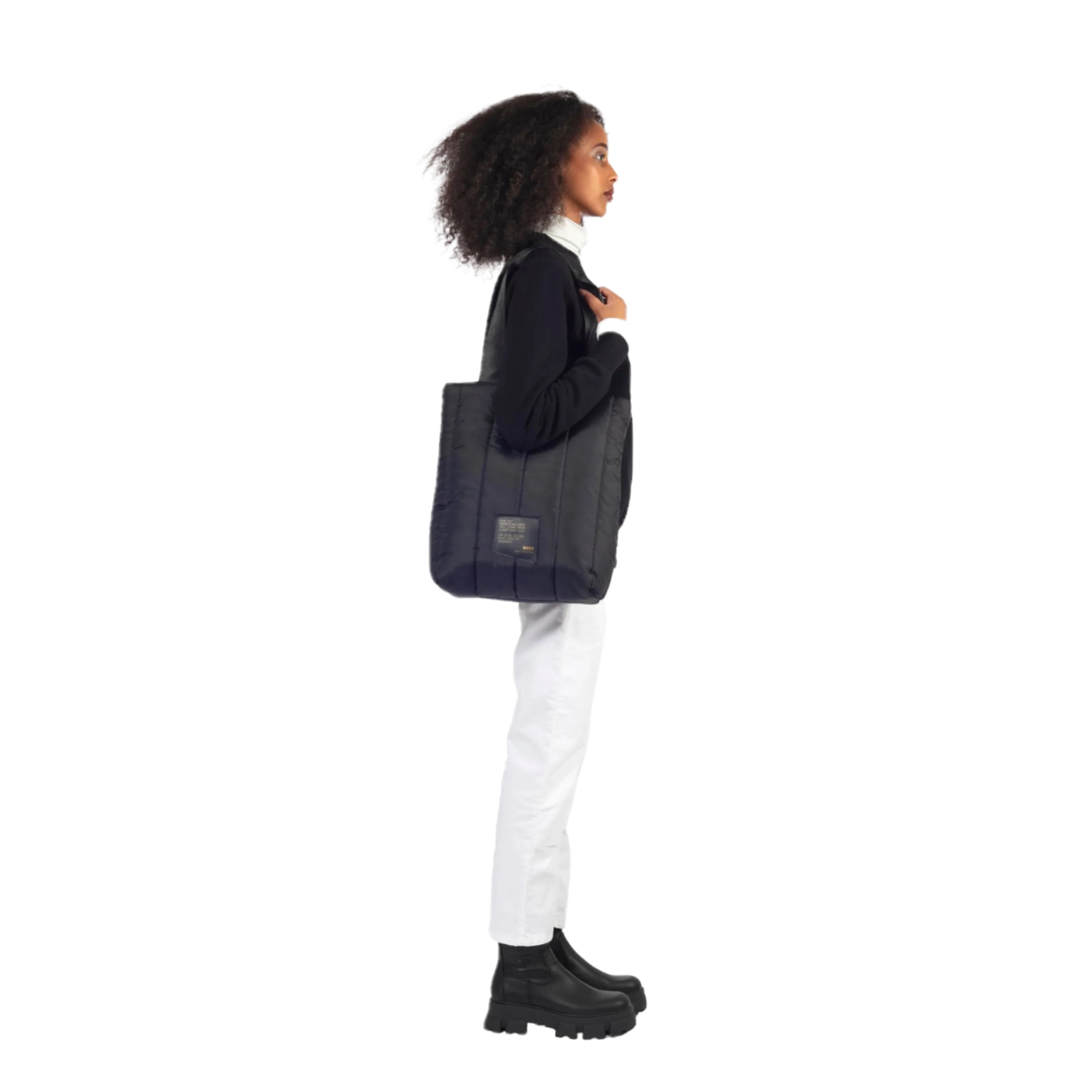 female model wearing a bedi reusable tote bag hanging from her left shoulder. bag 