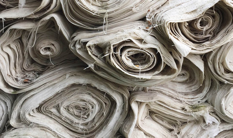 rolls of deadstock fabric stored piled on top of each other