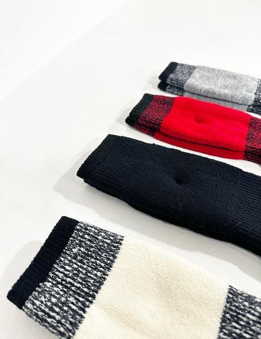close up of details on top of the socks display in a row on a white table (different colours from bottom to top) white, black, red and graphite