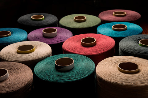 multicolour rows of econyl nylon fabric in a dark room