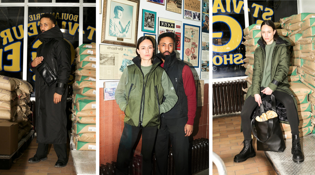 collage of three images inside a bagel factory (left) male model wearing a black extended parka and a black shoulder bag over (middle) male and female model both wearing sweaters, vests and black pants posing in front of a historical wall, (right) female model wearing a green extended parka over a green sweater and black pants holding a black tote bag full of bagels