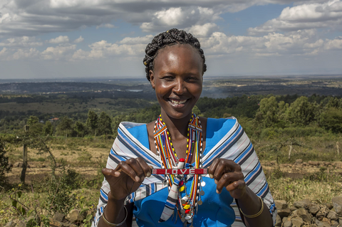 Love Is Project_woman in Kenya holding red LOVE bracelet