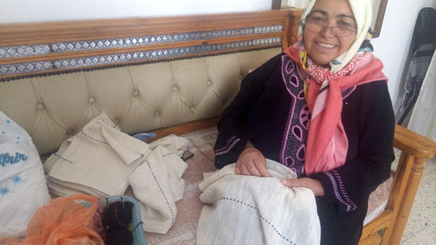 Woman sews fair trade certified pillow covers by hand for resale - Fair Trade Handmade in Tunisia - Shop THE WELLEST.