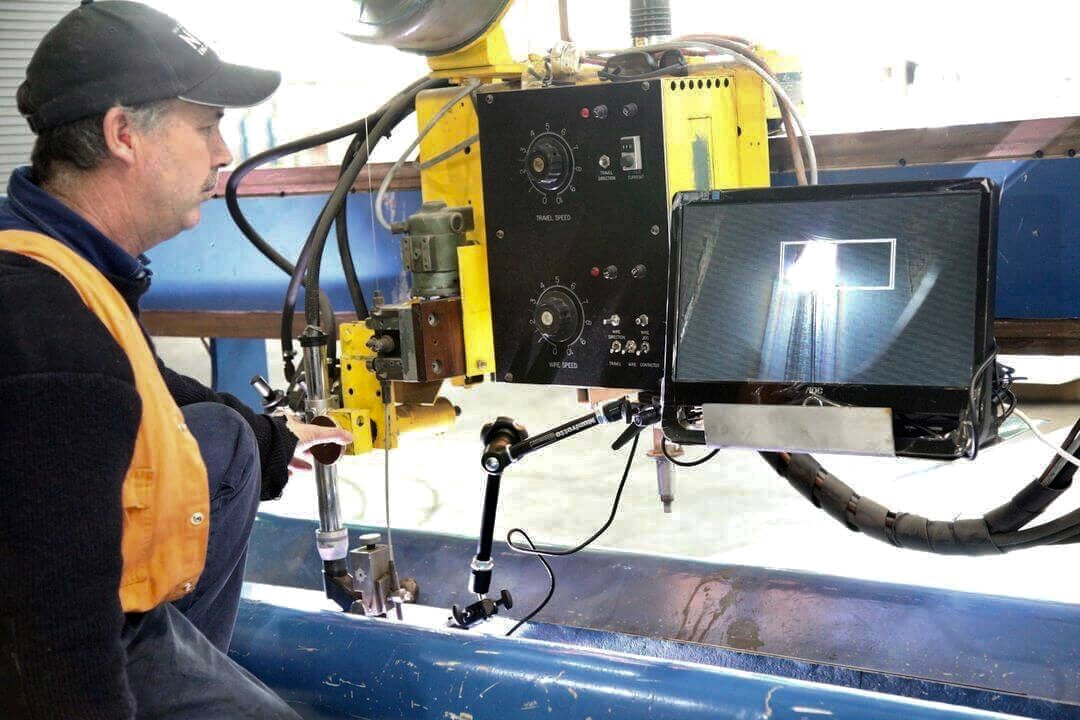 Operator views plasma welding seam on monitor while seated