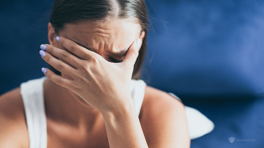 closeup of an unhappy woman crying with anxiety at home sitting on a blue couch