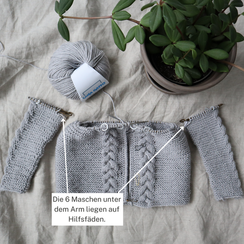 Step 1: The sleeves and body have been knitted separately. The sleeve stitches, which are under the arm, have already been placed on auxiliary threads. The remaining sleeve stitches are on stitch holders.