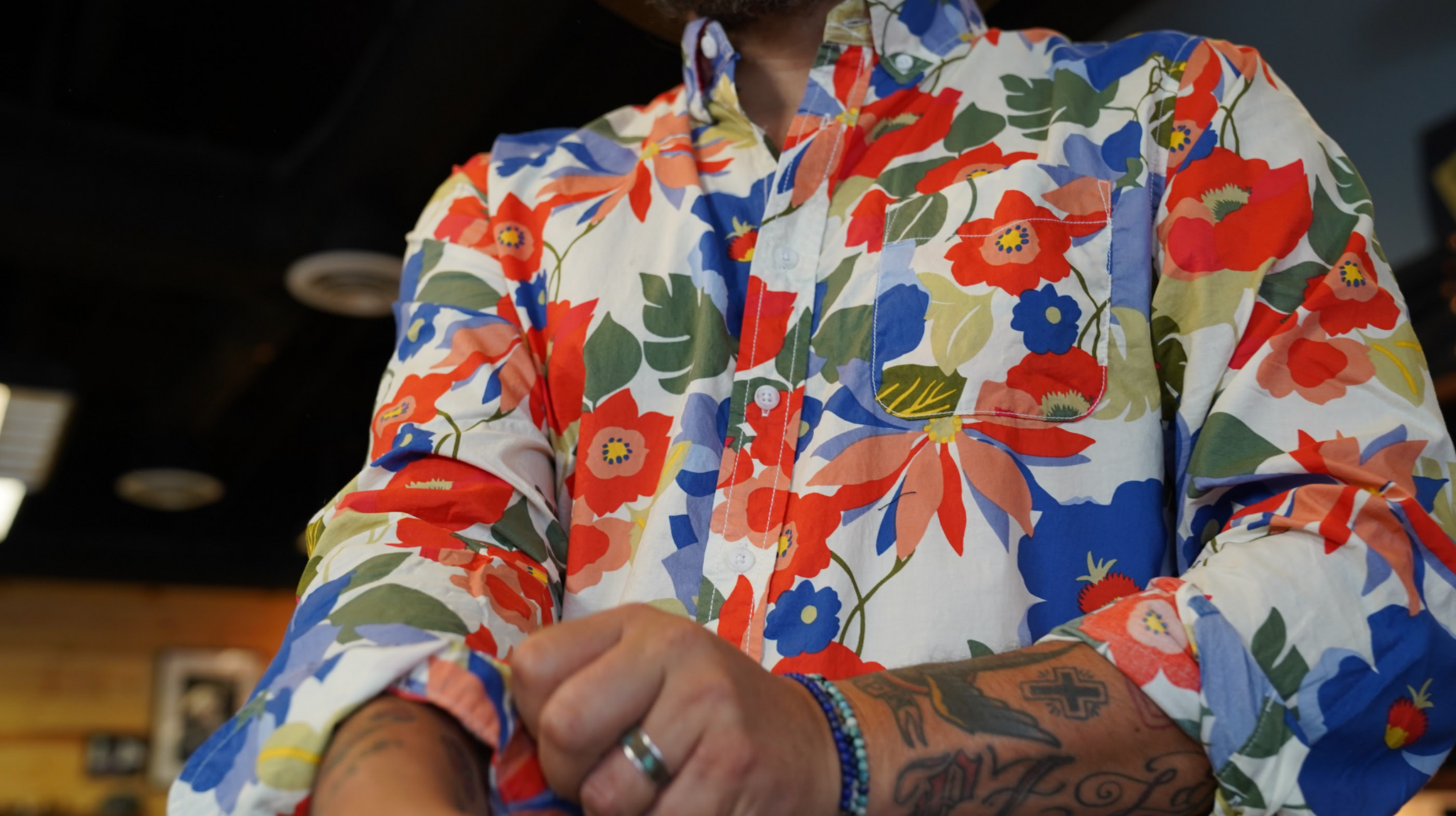 Model in floral shirt rolling up sleeve