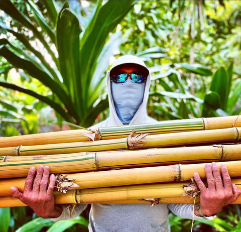 Man holding a bamboo plant.