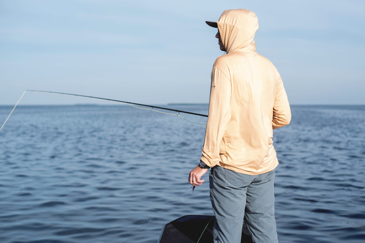 Model wearing the Angler Crossover Bamboo hoodie in burnt orange.