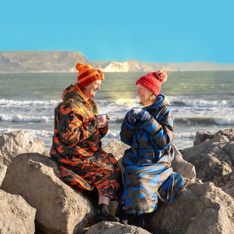 Sea swimmers at Weymouth Beach wrapped up warm and enjoying a cup of Dorset Tea