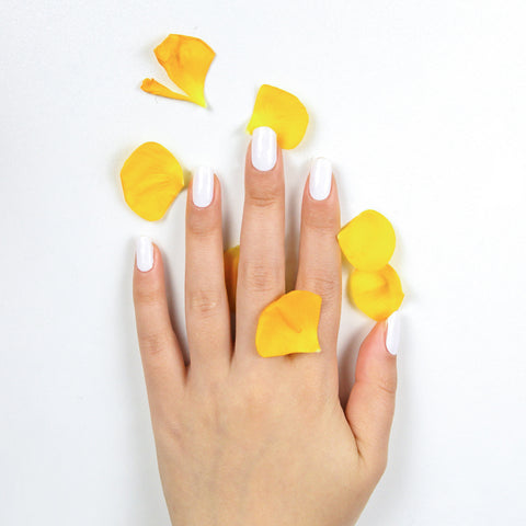 White colored nails and yellow rose petals