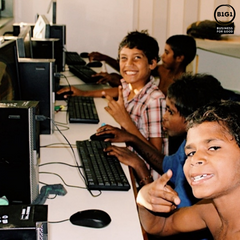 Young First Nations boys smiling and sitting infront of computers