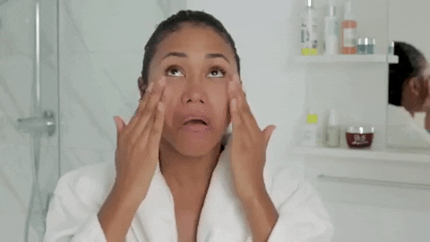 GIF of a woman applying cream to her face during her skincare.