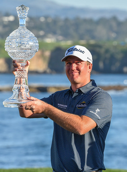 Tom Hoge holds the winning trophy