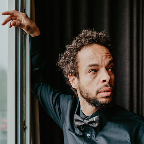 man wearing black shirt and black and gold cork bow tie