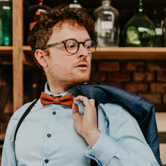 man in blue shirt with cognac cork bow tie