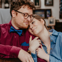 engaged couple hugging man with blue bow tie and pocket square