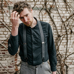 man wearing black shirt and recycled jeans braces