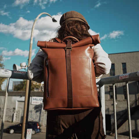 girl with a cap with a leather cognac and chocolate backpack on her back