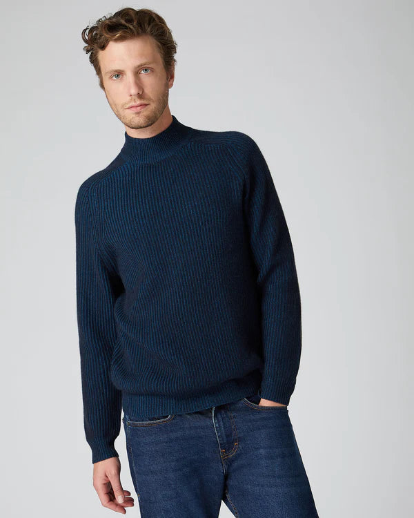 man standing wearing navy blue mock neck jumper