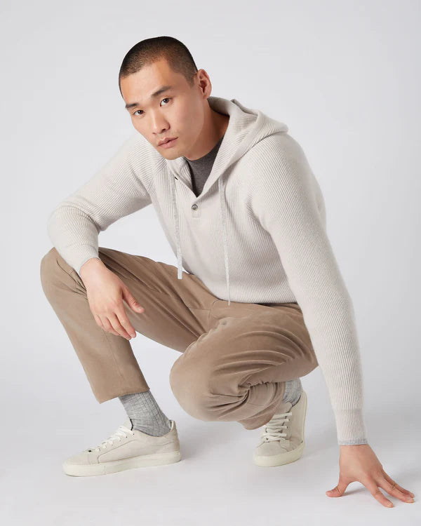 man kneeling down wearing a grey hooded jumper