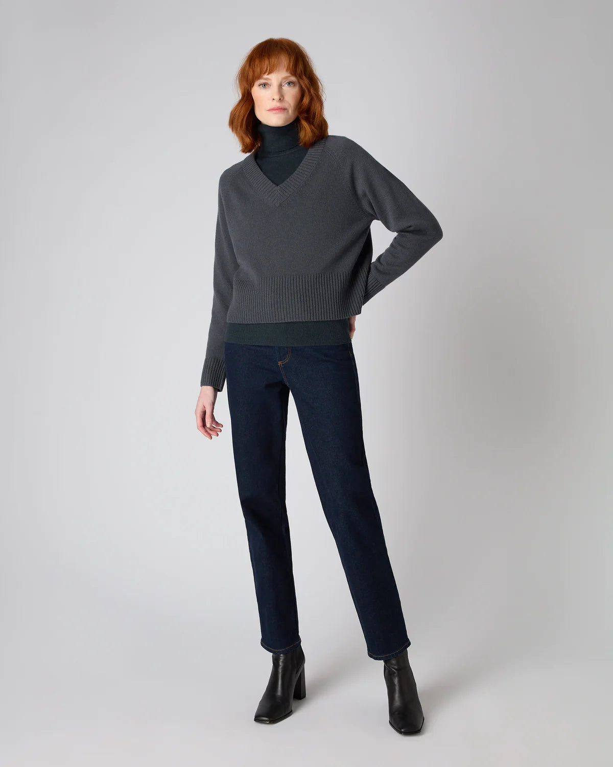 women wearing dark grey v-neck jumper with turtle neck and pants