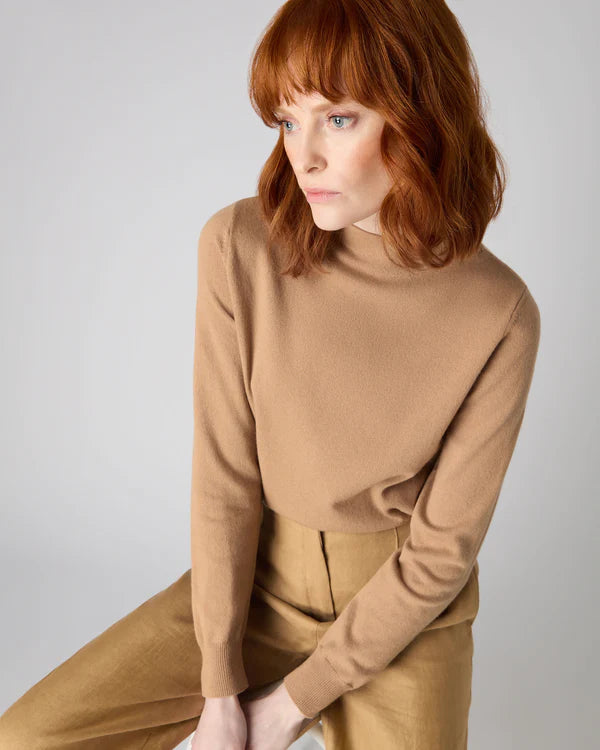 Woman wearing brown funnel neck jumper