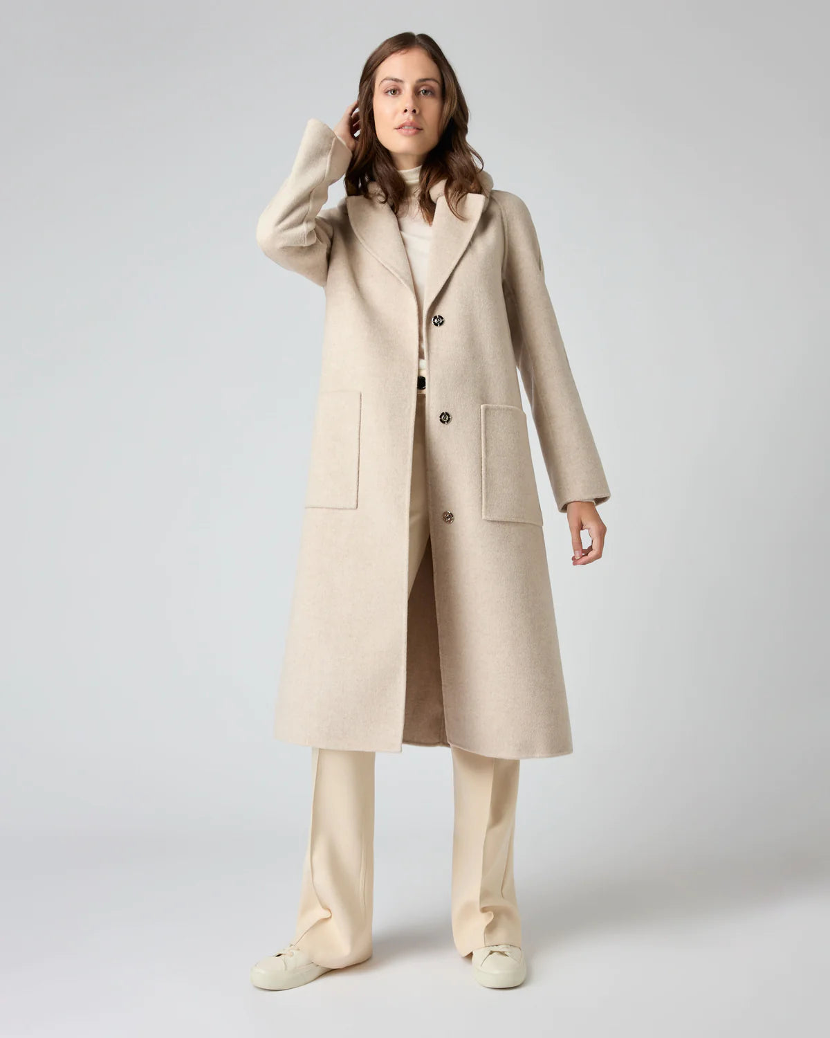 lady wearing light tone clothing with long trench coat and cashmere jumper