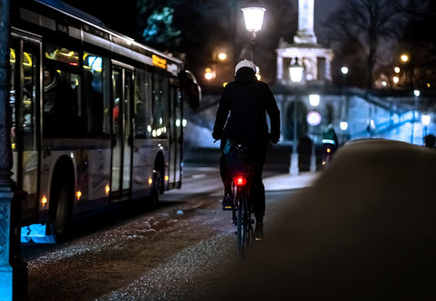 Person riding a bike at night in the city.