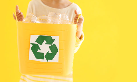 Person holding yellow recycling bin