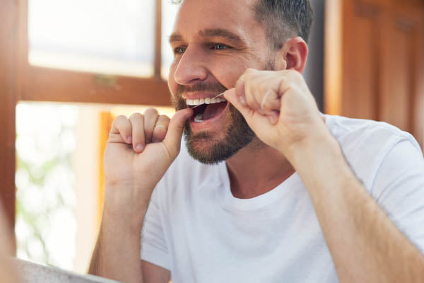 Man with silk dental floss