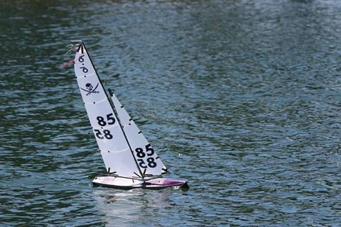 Finished purple fiberglass yacht sailing on the water.