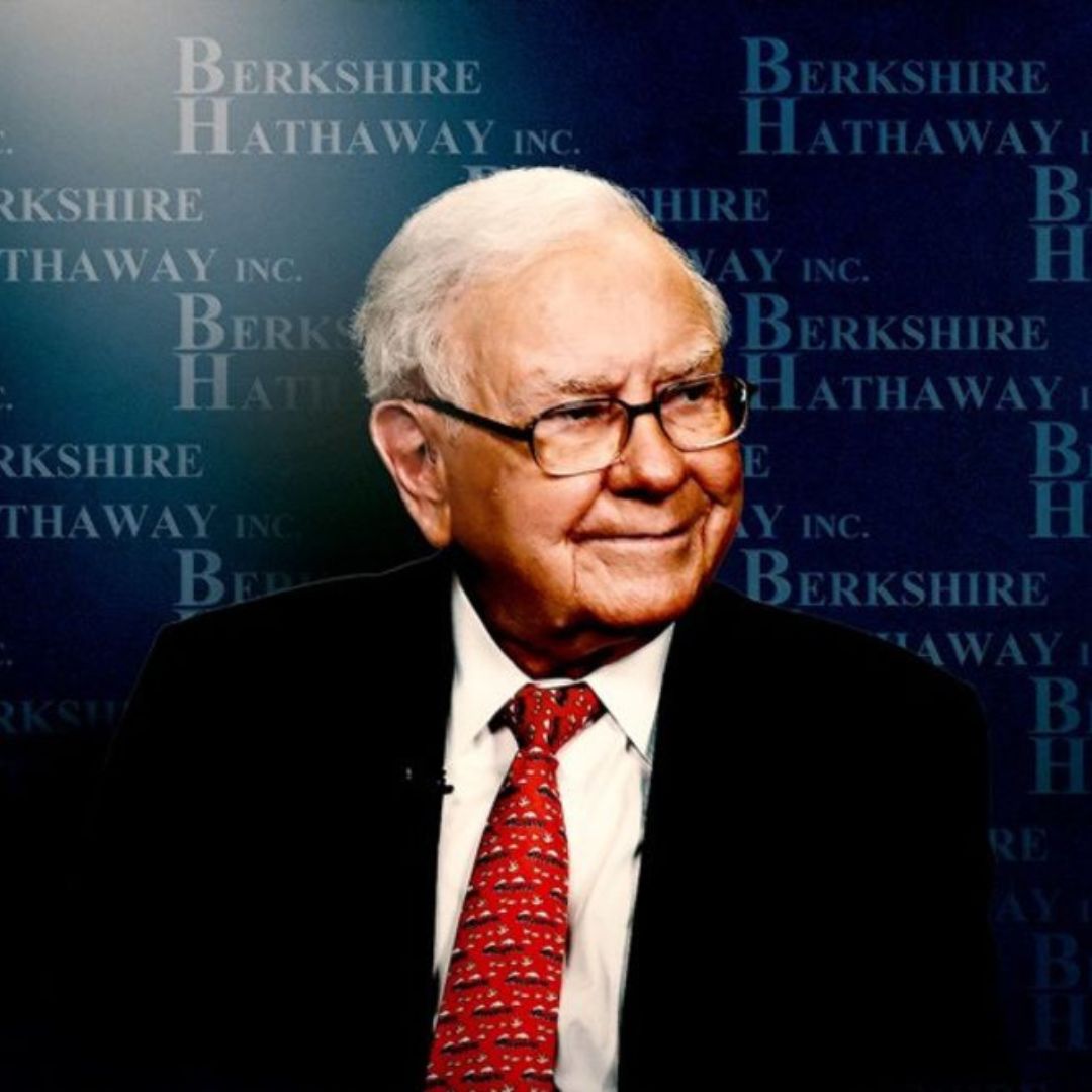 A photograph of Warren Buffett looking to the right with a Berkshire Hathaway background.