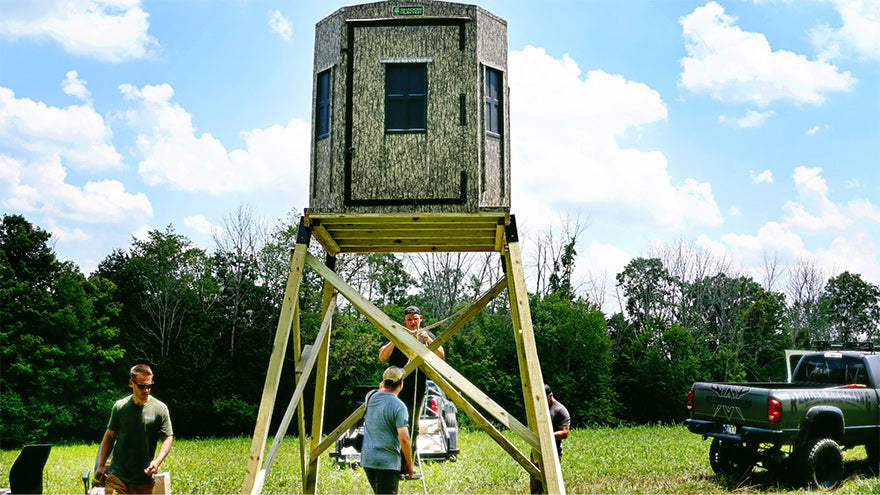 a group of hunters setting up an elevated hunting blind